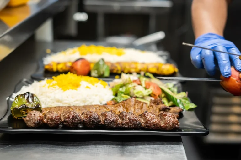 Chef plating barg kabob with saffron rice